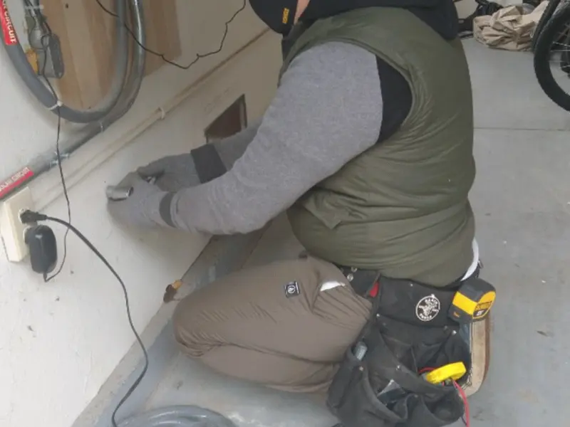 Electrician performing outlet wiring in a Rocky Mount garage